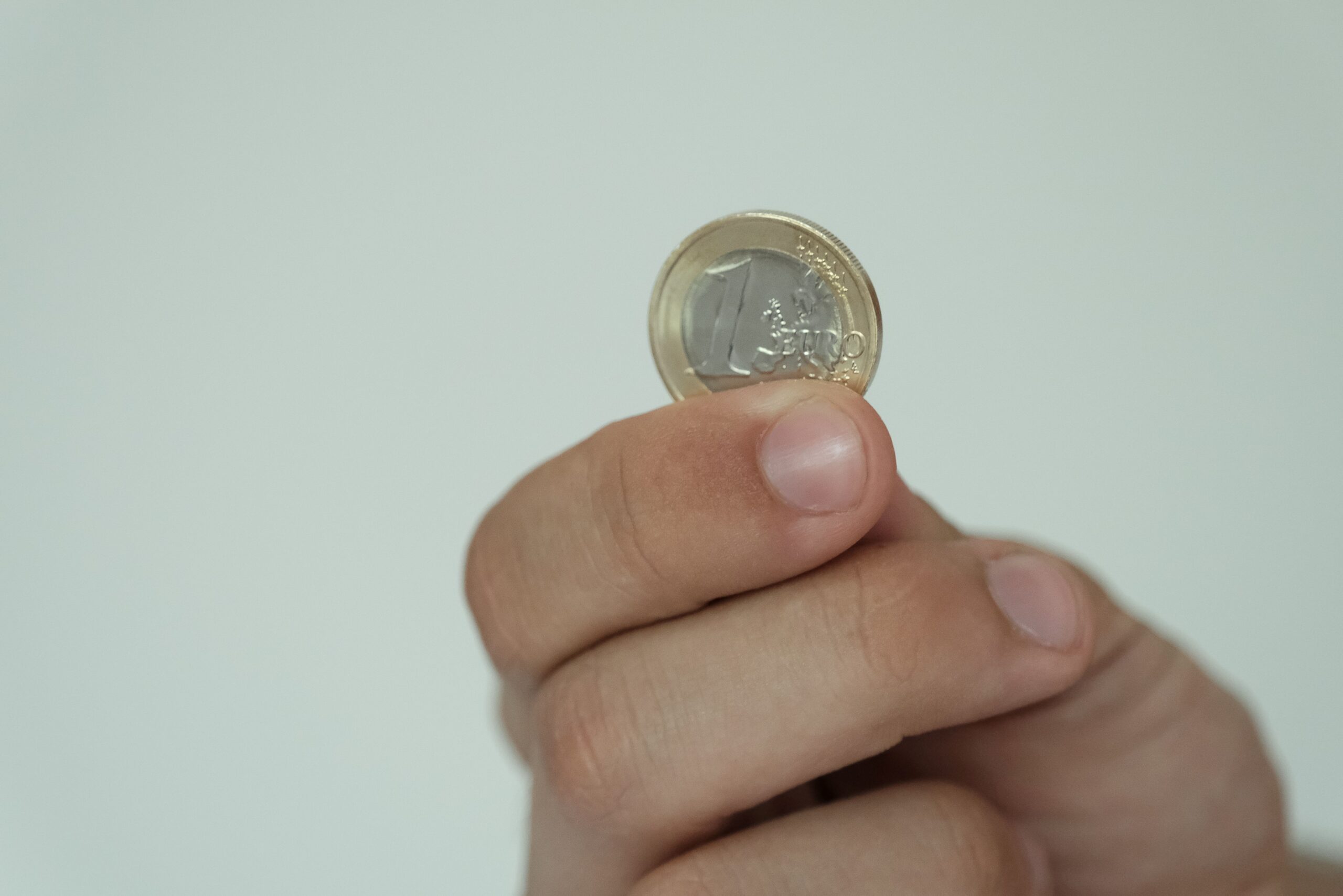 Foto einer Hand, die eine Euro-Münze hält